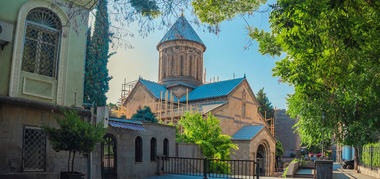 Ancient Surb Gevorg cathedral in old Tbilisi with trees framing and copy space