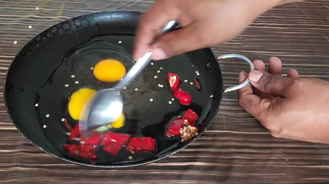 Stirring red chiles with eggs for breakfast