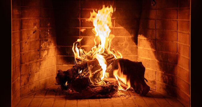Fireplace burning wood logs. Cozy warm home in winter, Christmas holiday bonfire. Fire flames