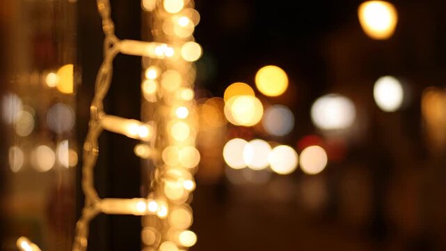 Close-up of warm string lights at night, bokeh effect, festive atmosphere.