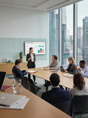 Fototapeta premium Businesswoman Presenting to Diverse Team in Modern Office Conference Room
