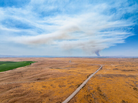 Vast open field under a clear sky with clouds