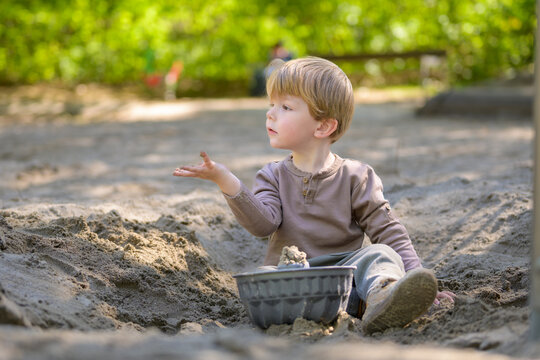Toddler Playing Calmly In Sand