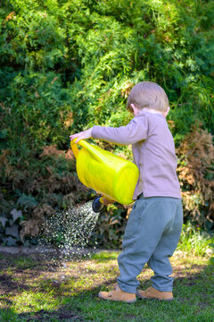 Toddler Watering Plants Sunny Garden