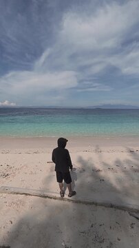 Person Standing on Beach Facing Ocean