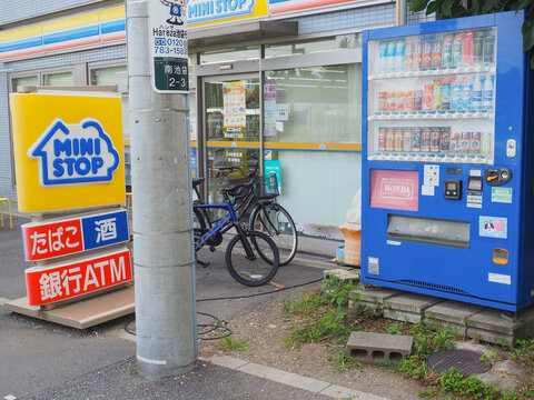 TOKYO, JAPAN - July 11, 2026: Sign and vending drinks vending machine in the front of a Ministop convenience store in Tokyo Toshima Ward.