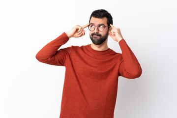 Naklejka premium Caucasian handsome man with beard over isolated white background having doubts and thinking