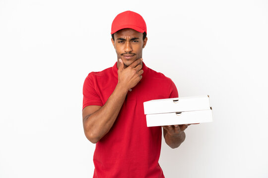 African American pizza delivery man picking up pizza boxes over isolated white wall thinking