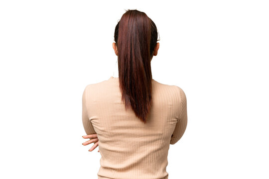 Young beauty woman over isolated chroma key background in back position