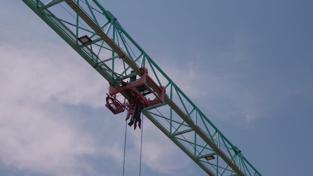 Close up of tower crane jib against cloudy blue sky