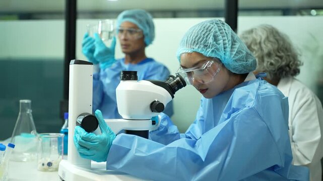 Professional ecologists testing wastewater purity using scientific equipment in sterile cleanroom, environmental sustainability concept.