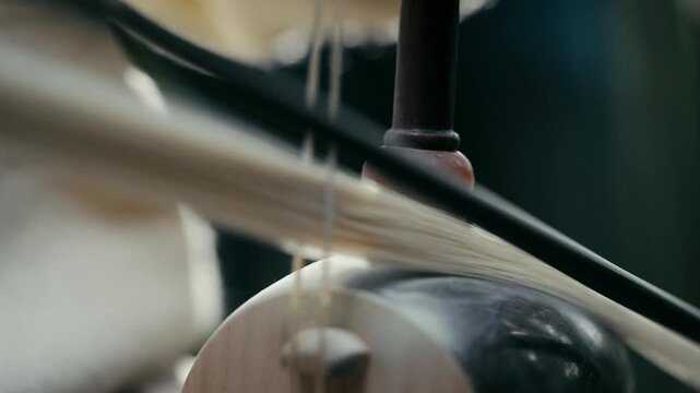 Close-up of playing Haegeum, a traditional Korean string instrument with a bow 한국 전통 악기 해금의 울림통과 활대가 교차하는 역동적인 연주 클로즈업