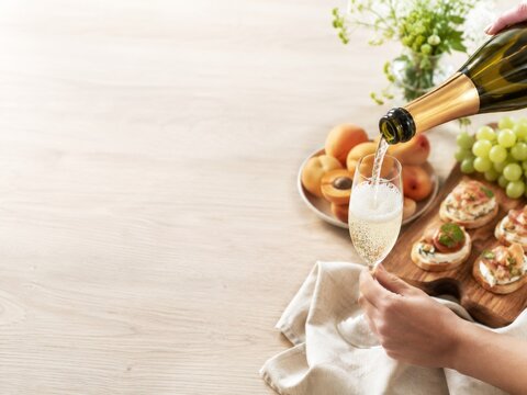Celebraci&oacute;n con vino espumoso y aperitivos en una mesa