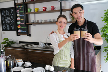 Cafe barista coffee cup apron couple kitchen smile cafe worker hold takeaway drink in modern coffee...