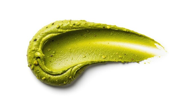 A thick, creamy smear of vibrant green pistachio nut paste artistically spread across a plain white surface, highlighting rich oily texture, ground, dessert, rich