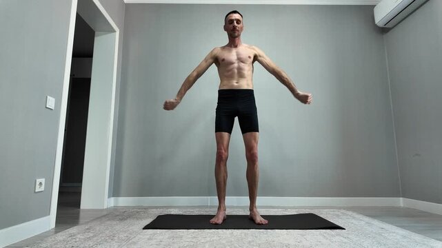 A muscular man with a bare chest performs squats and a full-body workout to maintain a healthy lifestyle. Timelapse