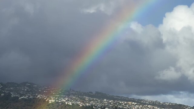 Rainbow is an optical phenomenon caused by refraction. Time Lapse of City of Honolulu, Oahu island, Hawaii. In the distance is the Koʻolau Range. Cumulus clouds with Trade Wind.