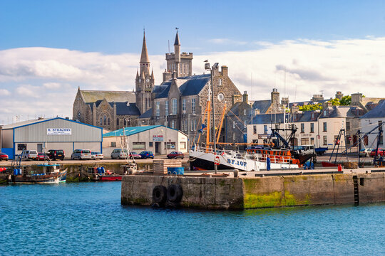 Harbor scene in a traditional coastal scottish town featuring moored fishing boats