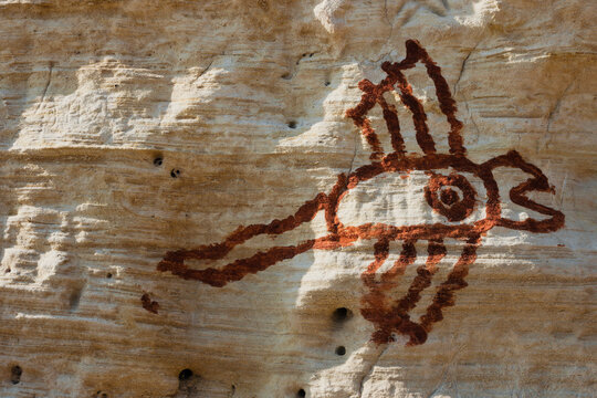 Rock drawings and scratch-carvings. Pictographs and abstract signs made with red ochre on the limestone cliffs along the "Cammino del Salento" hiking trail. Puglia Region, Italy.
