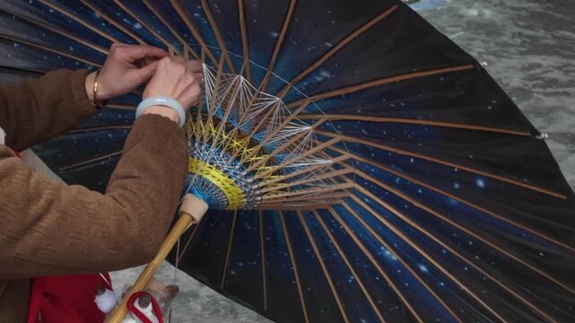 Craftsmen are making oil paper umbrellas
