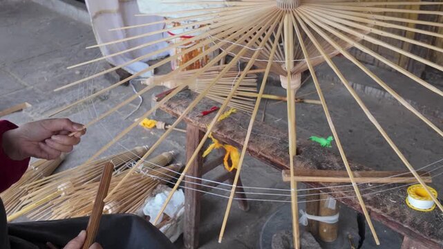 Craftsmen are making oil paper umbrellas
