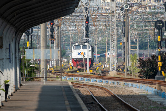 Jakarta, Indonesia - July 02, 2026: A KAI diesel locomotive stands on the tracks near the platform at Jakarta Kota Station beneath overhead catenary wires and railway signals.