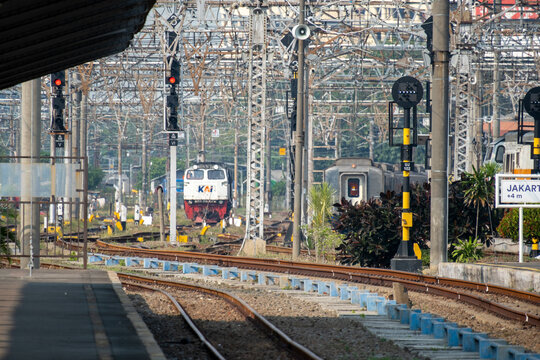 Jakarta, Indonesia - July 02, 2026: A KAI diesel locomotive stands on the tracks near the platform at Jakarta Kota Station beneath overhead catenary wires and railway signals.