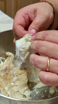 Woman's hands preparing salted cod fish for cooking