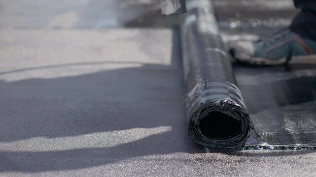Unrolling bitumen roofing membrane for flat roof waterproofing