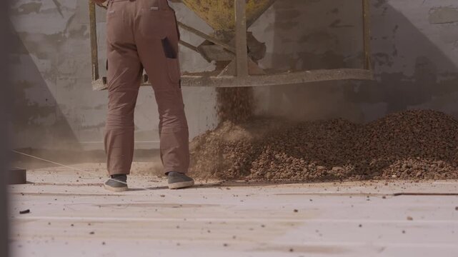 Spreading expanded clay aggregate across flat roof for thermal insulation