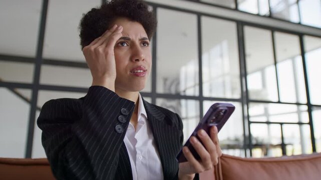 Distressed Businesswoman Reading Layoff Notification on Smartphone