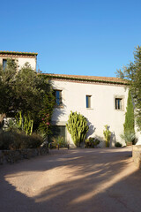 Naklejka premium Large mediterranean estate facade with gravel driveway and xeriscape desert garden landscaping