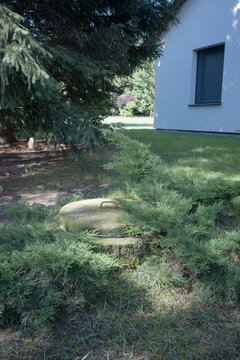 Concrete septic tank in front of a single-family house.