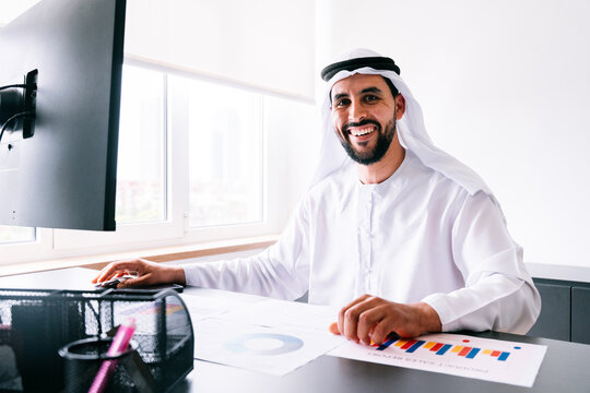 Arab businessman smiling at office working on computer