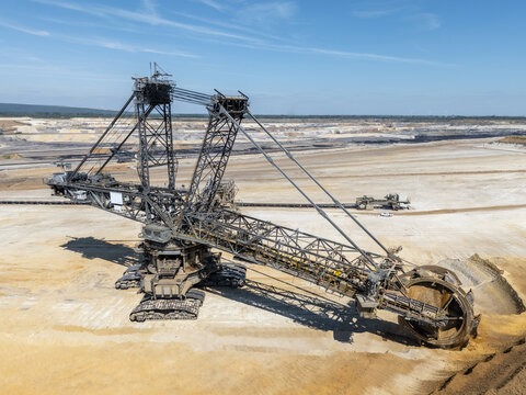 Large open cast coal lignite mine near Aachen, Germany, with heavy machinery and layers of exposed earth for fossil fuel power stations generating electricity