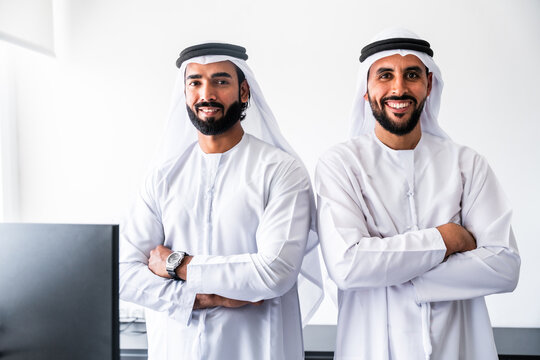 Arab business colleagues standing smiling in office
