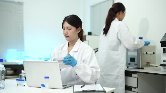 environmental scientists analyzing water quality samples with centrifuge and petri dish in laboratory.
