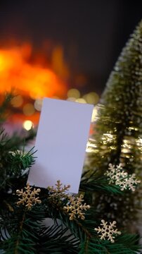 Christmas tree, empty blank card. Space for text. Magic of the holiday season. Warm string lights twinkle gently.  Fireplace,  flame, fir branches adds comforting warmth, the subtle scent. Copy space