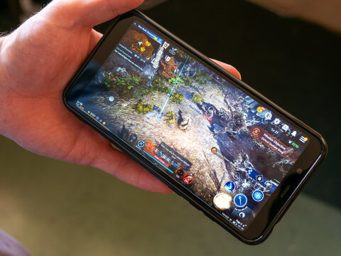Cork, Ireland, July 31, 2022. A android smartphone in the hands of a white man. Playing mobile MMORPG Black Desert Mobile. A popular Korean mobile game on a smartphone screen, illustrative editorial.