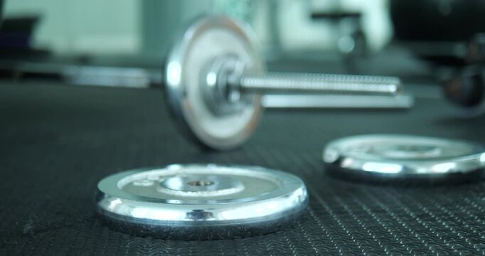 Close up of chrome weight plates on rubber floor in gym