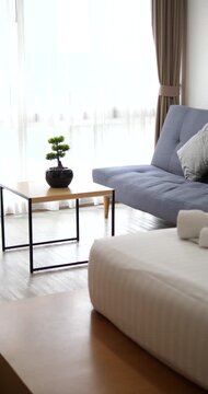 White rolled towels on bed with blurry living room interior background