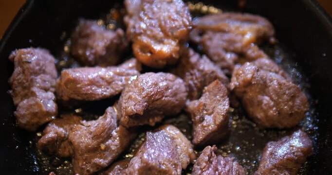 Close up of juicy diced beef steak cubes on hot pan