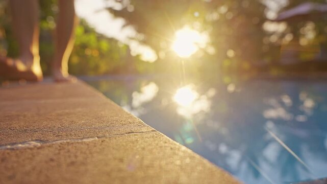 Person standing barefoot beside a tropical swimming pool during warm morning light. The peaceful atmosphere, reflections on the water, and surrounding greenery evoke themes of relaxation, wellness, va