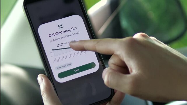 Tracking personal health progress via smartphone. User reviews a 35-day calorie trend and easily switches to check their weight loss journey. Great for wellness coaching, personal fitness blogs