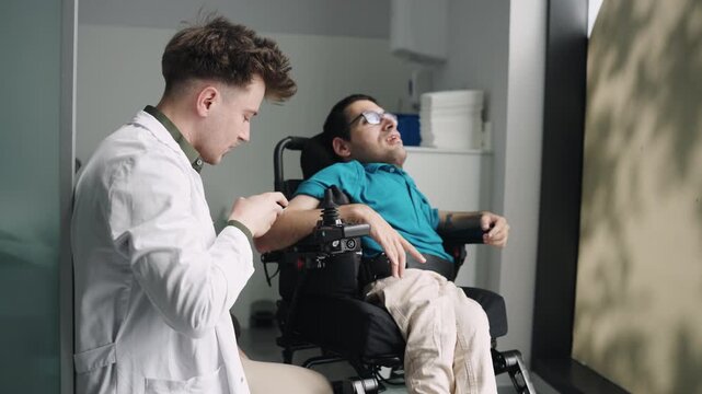 Young doctor helping a person with spina bifida sitting in a modern wheelchair. Professional medical assistance and healthcare concept