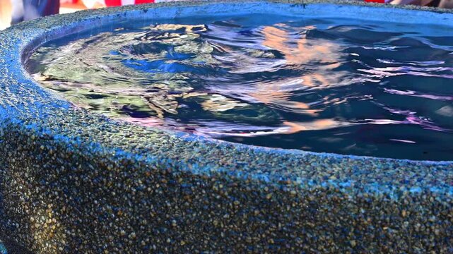 神社の水盤に落ちる水滴