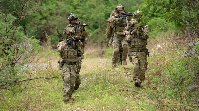 Special forces unit advances through forest terrain while maintaining tactical formation and security coverage