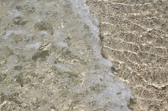 Waves on the summer sand beach with fresh clear water. 