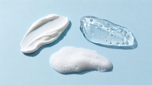 cosmetic cream, transparent gel and cleansing foam smears on blue background. Texture of beauty skincare product. Sample of moisturizer, liquid serum and soap bubble for skin care