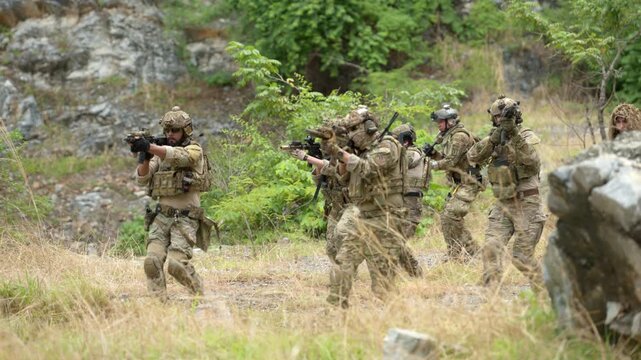 Military personnel conduct patrol and communication activities during a tactical field operation in a natural environment